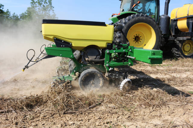 Tractor-drawn row planter planting into strip-tilled rows